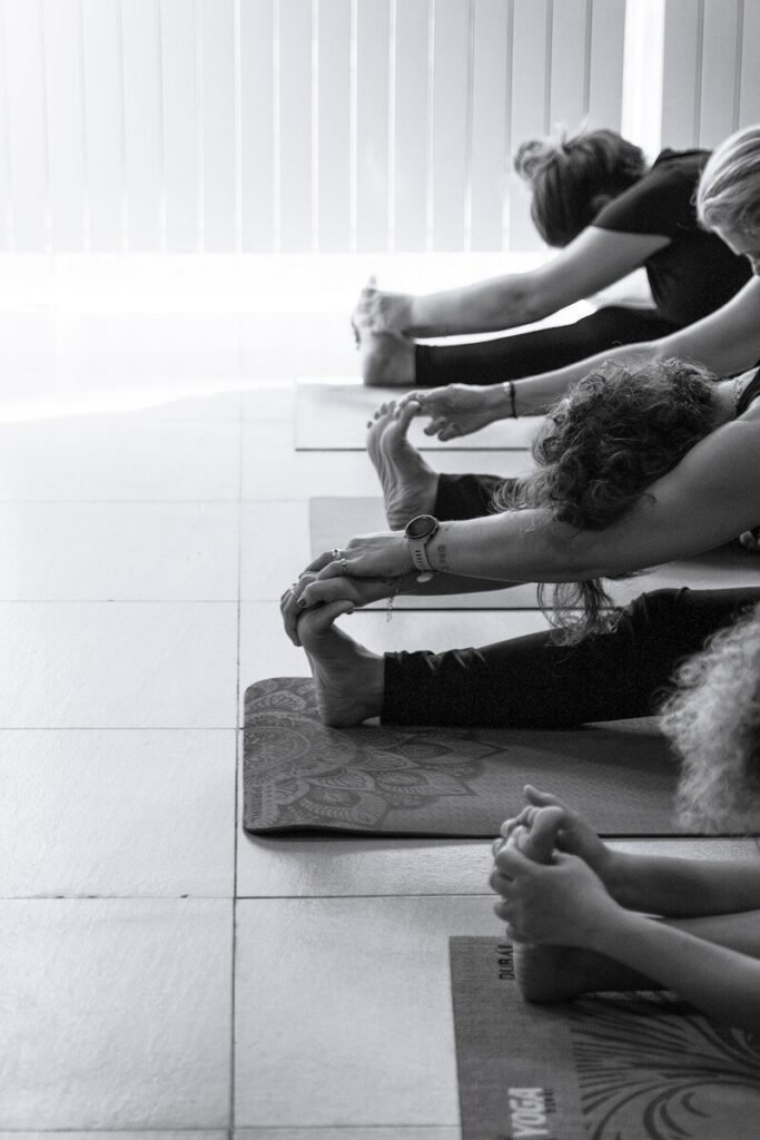 People stretching on yoga mats in a studio